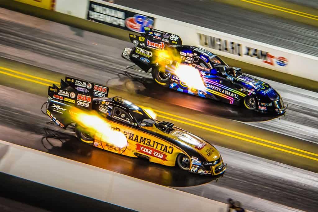 Funny Cars race down zMAX Dragway during the NHRA NTK Carolina Nationals